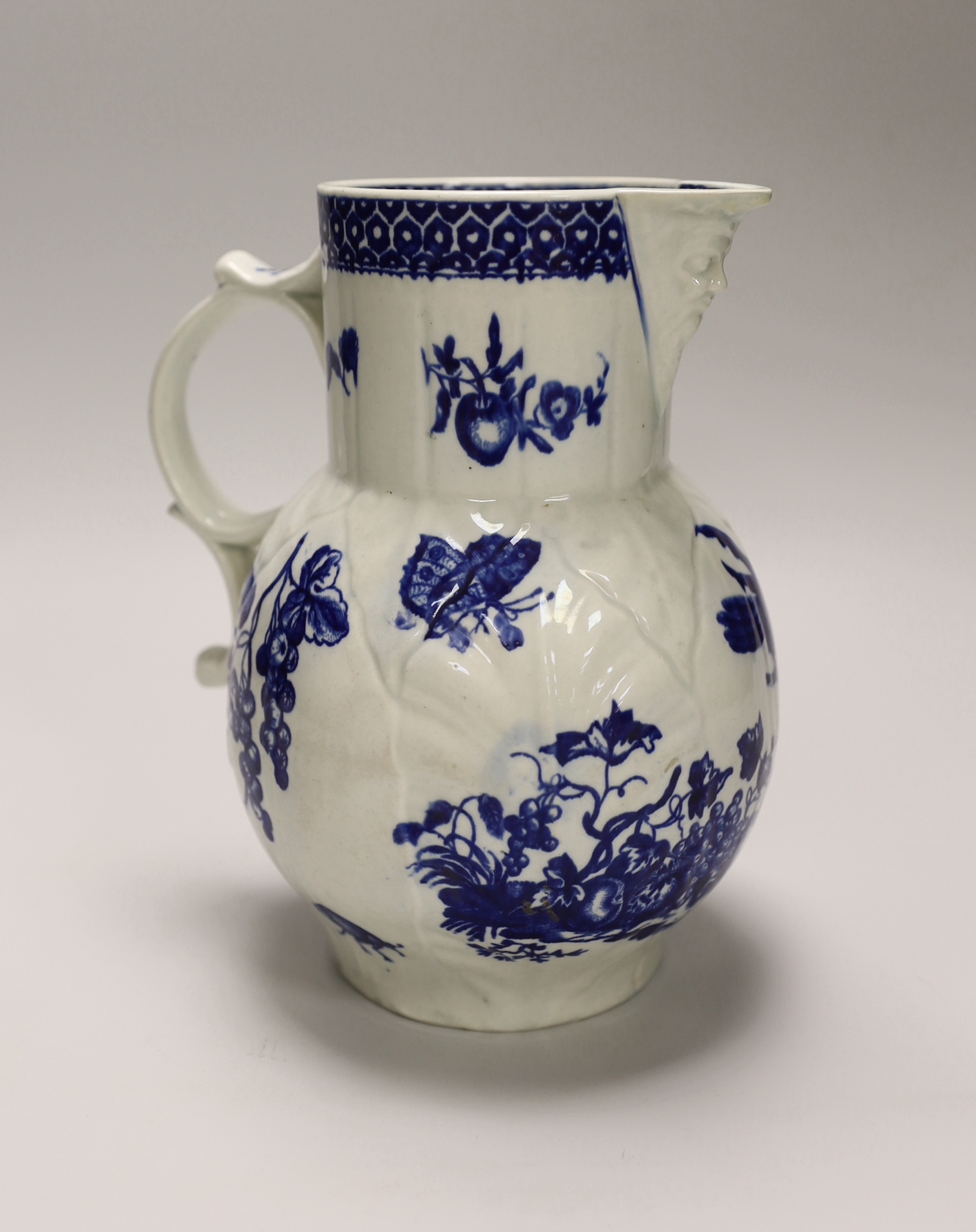 An 18th century Worcester fine mask jug decorated with the Parrot Pecking Fruit pattern, disguised numeral mark, 21cms high